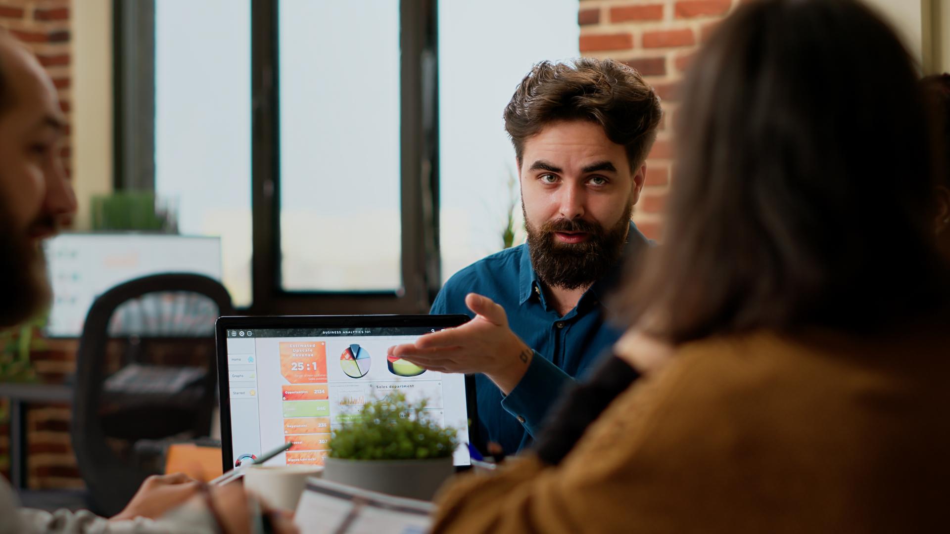 Project Manager Pointing Business Charts Laptop Showing Online Research Data Colleagues People Planning Startup Project Presentation With Charts Creating Successful Report